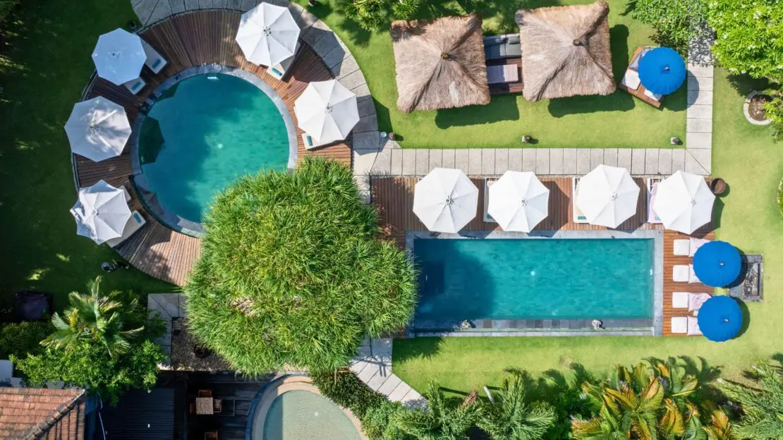 Resort swimming pool surrounded by palm trees at S Resorts Hidden Valley Bali